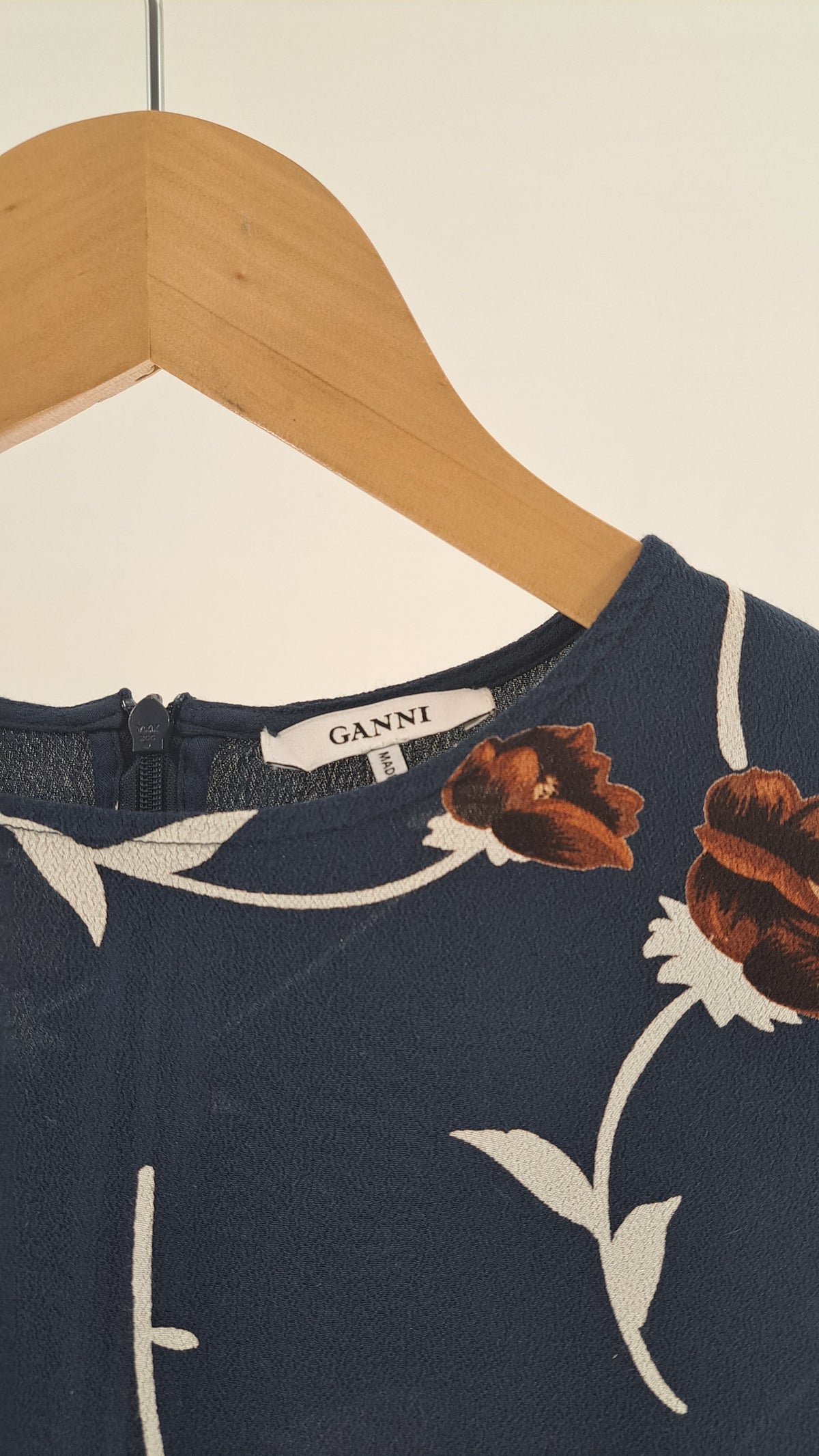 Nærbillede af halsudskæring, mærke og blomsterprint på GANNI kjole