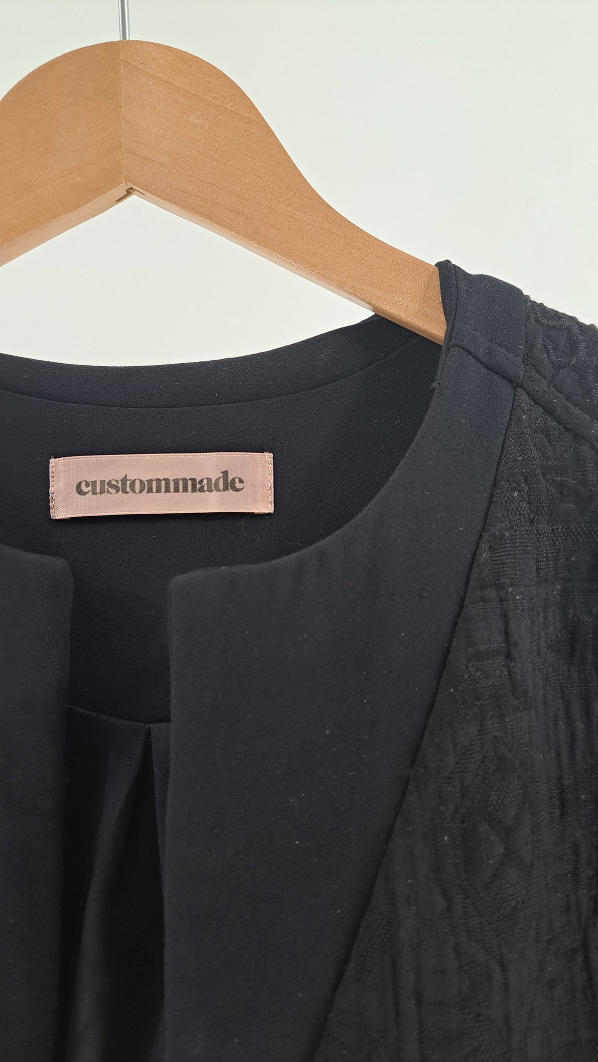 Nærbillede af stofstruktur og halsudskæring på Custommade jakke