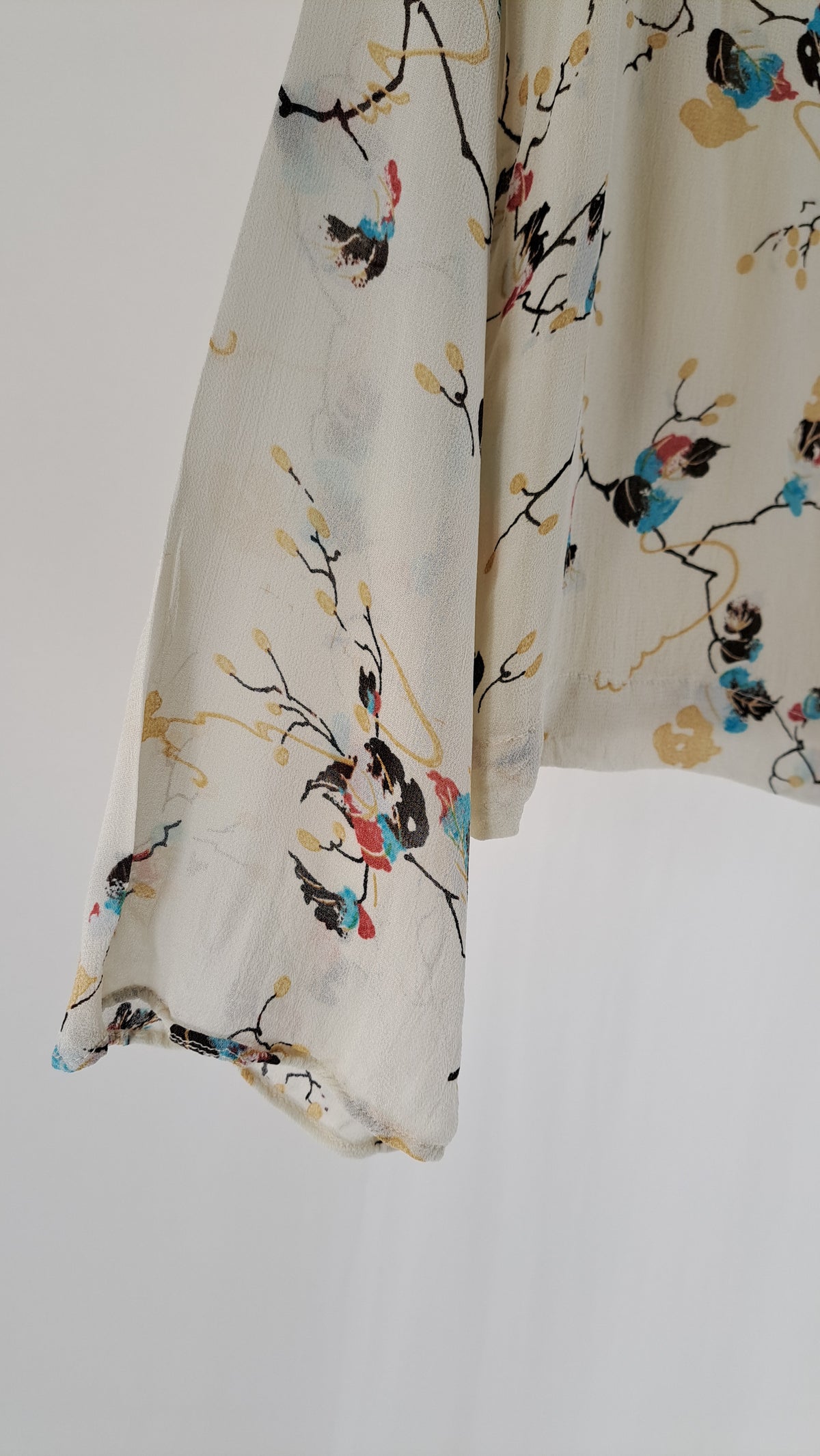 Nærbillede af vidt ærme og detalje på blomstret GANNI viskosebluse