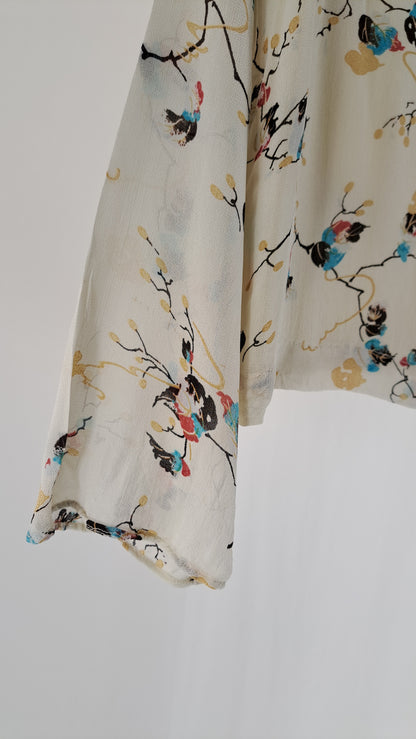 Nærbillede af vidt ærme og detalje på blomstret GANNI viskosebluse