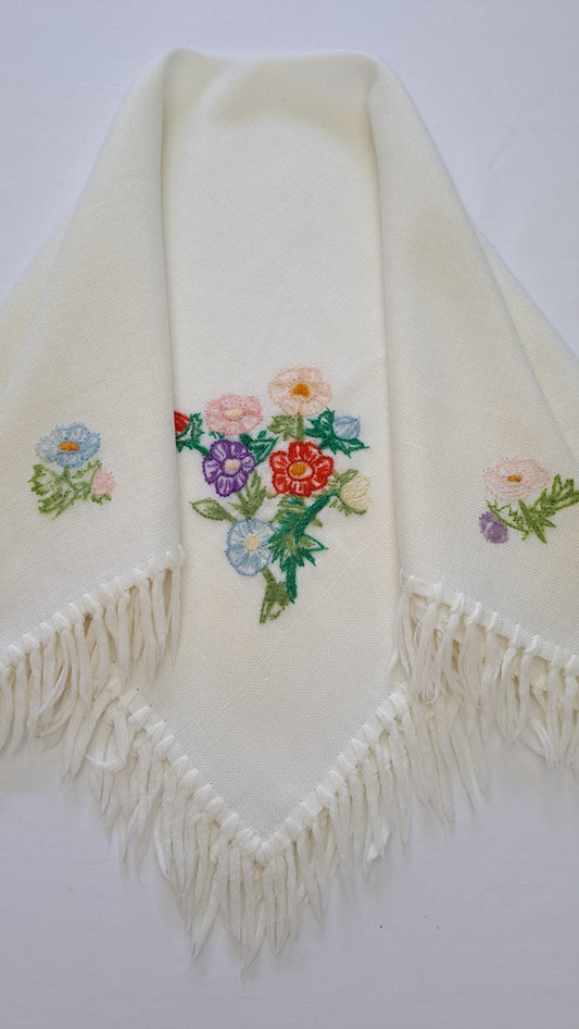 Cremefarvet vintage tørklæde med farverigt blomsterbroderi og frynser foldet i en spids