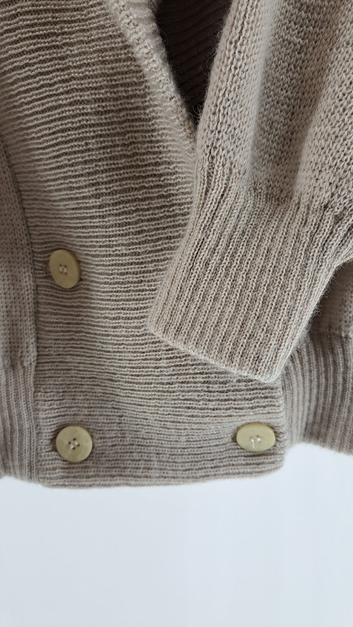 Nærbillede af dobbeltradet knaplukning og ribkant på vintage uldcardigan
