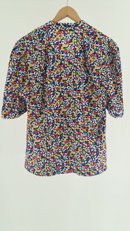 Nærbillede af knapdetalje på skulder af farverig vintage bluse