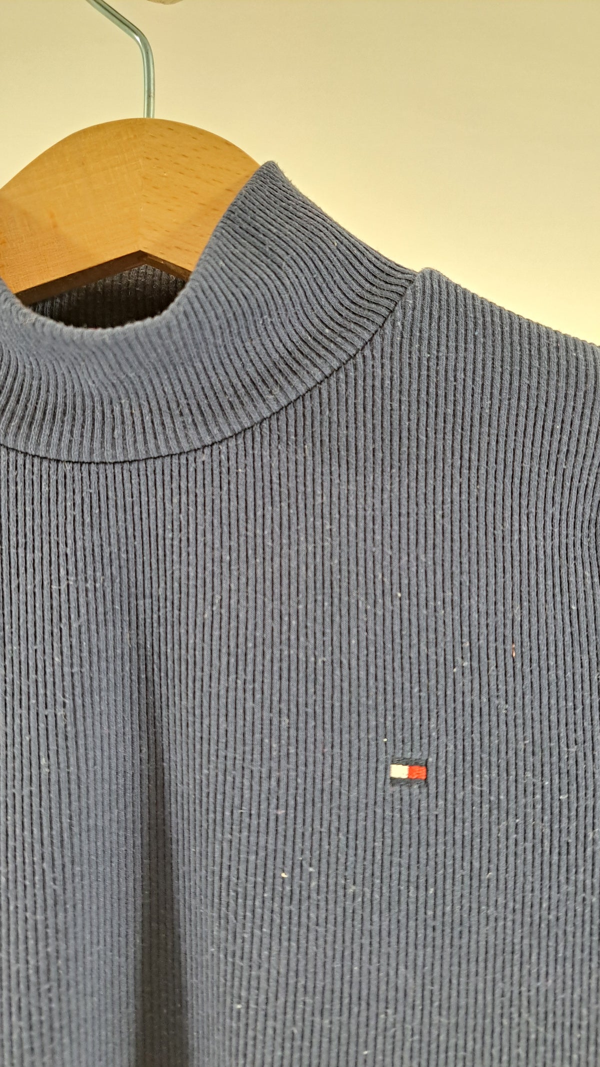Nærbillede af høj hals, ribstruktur og broderet Tommy Hilfiger flaglogo på børnebluse