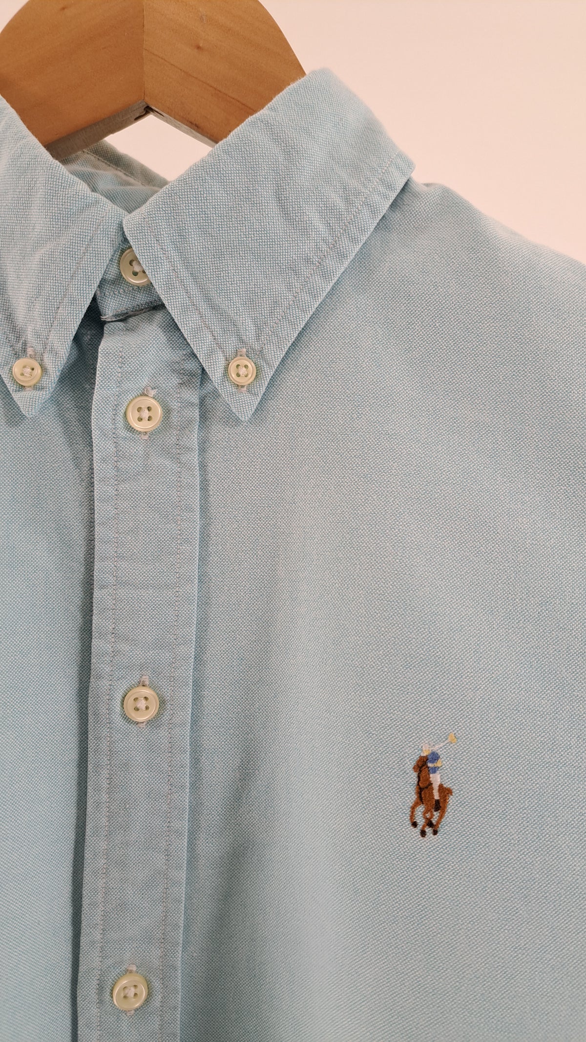 Nærbillede af button-down krave og broderet ponylogo på lyseblå Ralph Lauren skjorte