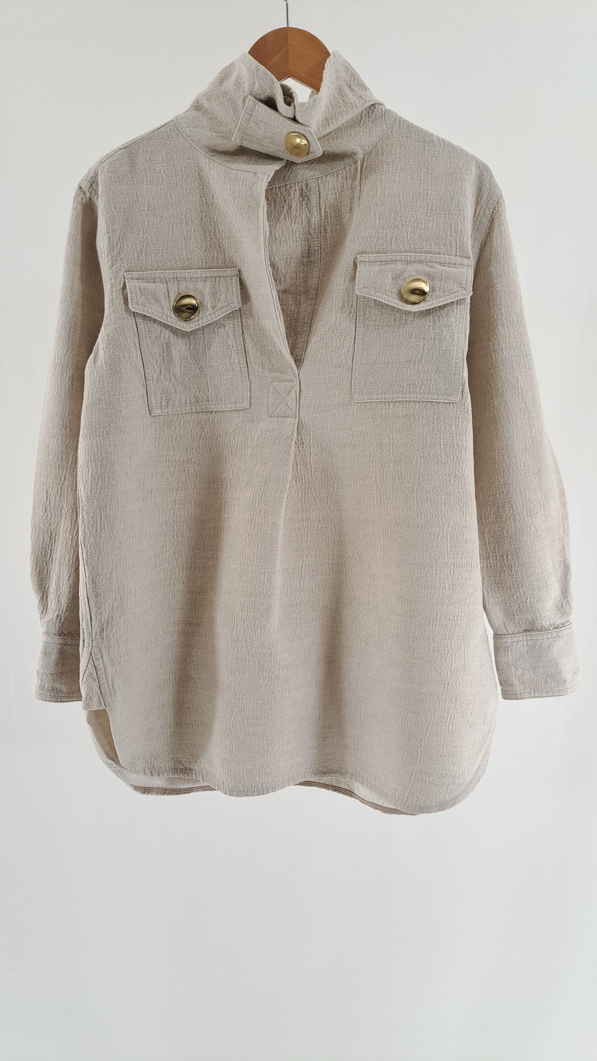 Lys beige By Malene Birger skjortekjole med guldknapper og brystlommer set forfra