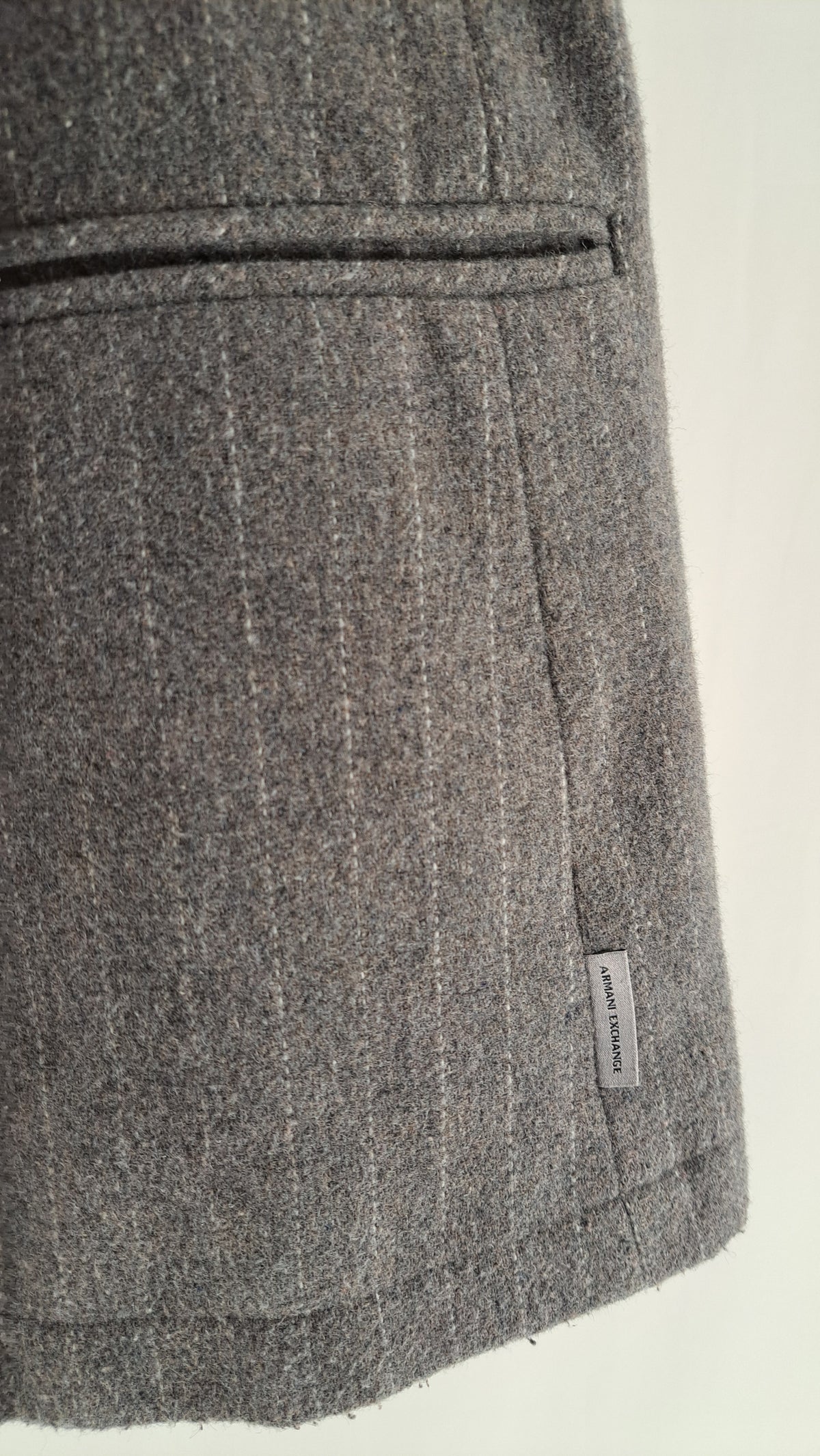 Nærbillede af sidelomme og mønstret uldtekstil på Armani blazer