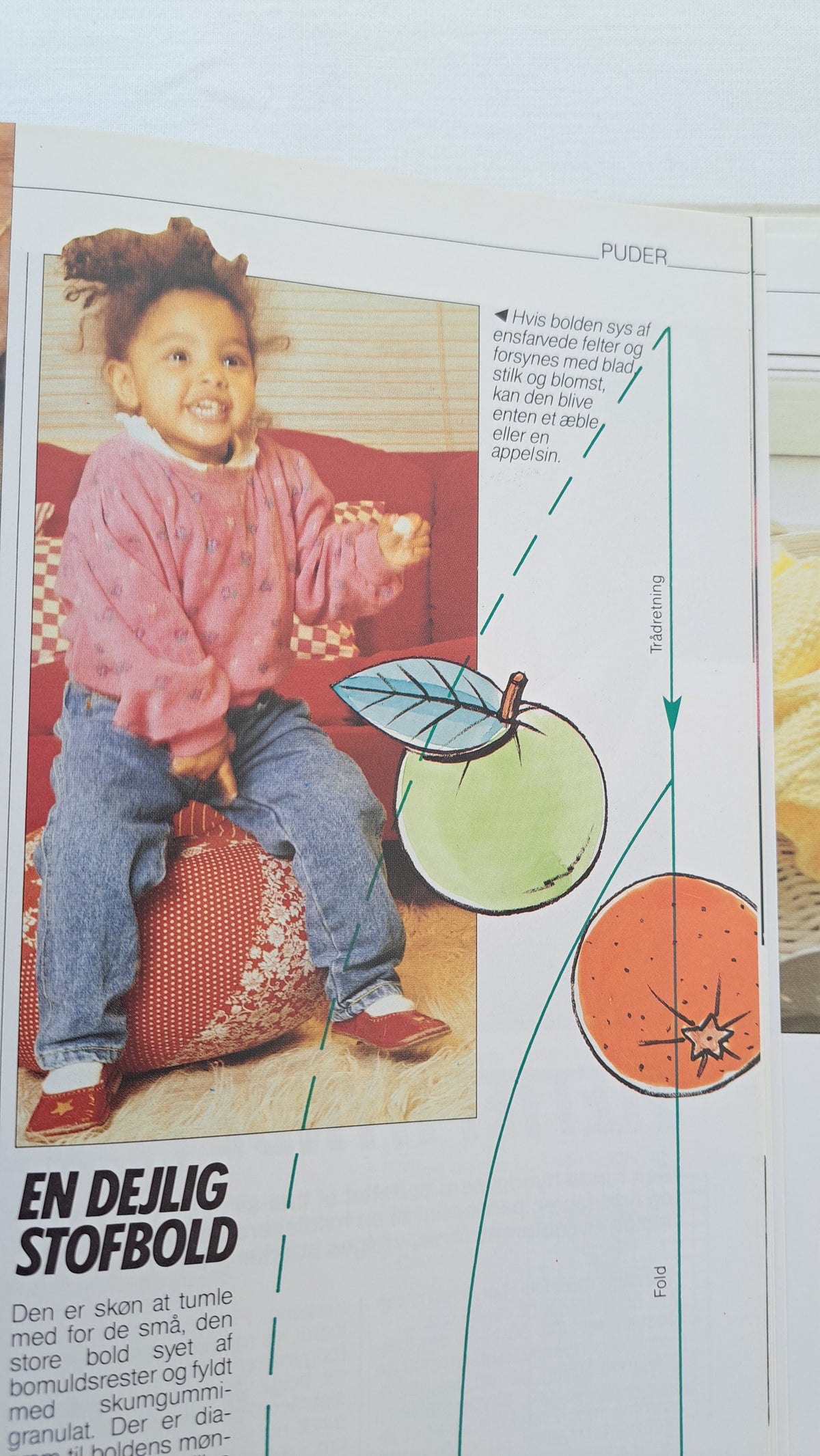 Opslag i vintage håndarbejdsbog med ideer og mønstre til børnetøj og farverige applikationer