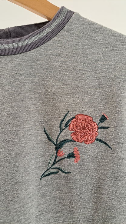Nærbillede af broderet rosa blomst på brystet af Minymo kjole