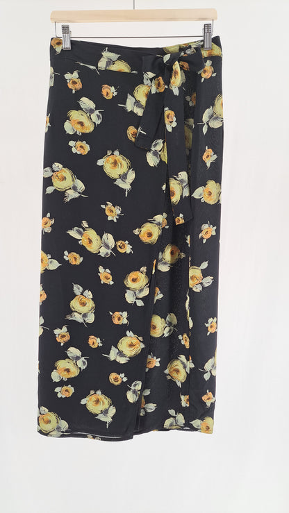 Lang, sort Passage slå-om-nederdel med gult blomsterprint set forfra